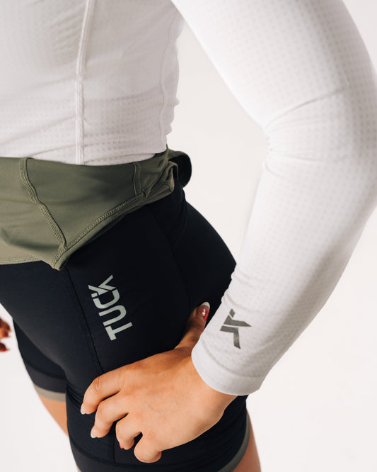 Person wearing a black Tuck product on their waist with a white background