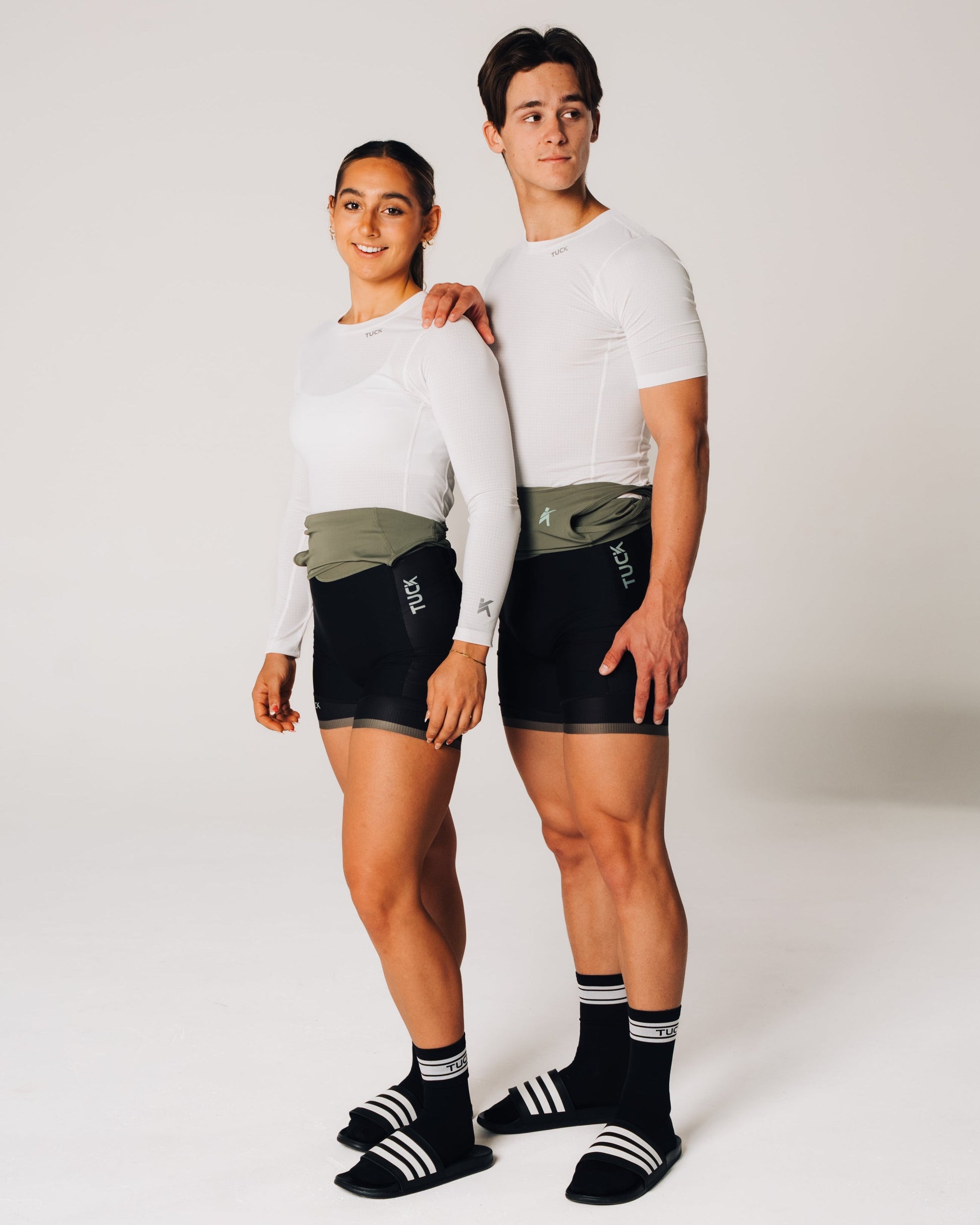 Two people wearing athletic wear standing against a white background