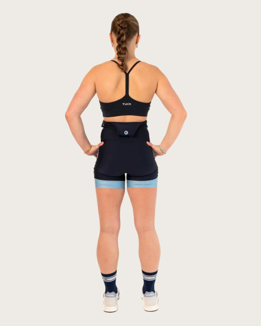 Person wearing a black athletic outfit with a visible brand logo on a white background